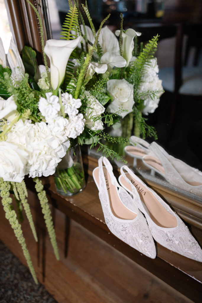 Bridal accessories including shoes, jewelry, and bouquet.