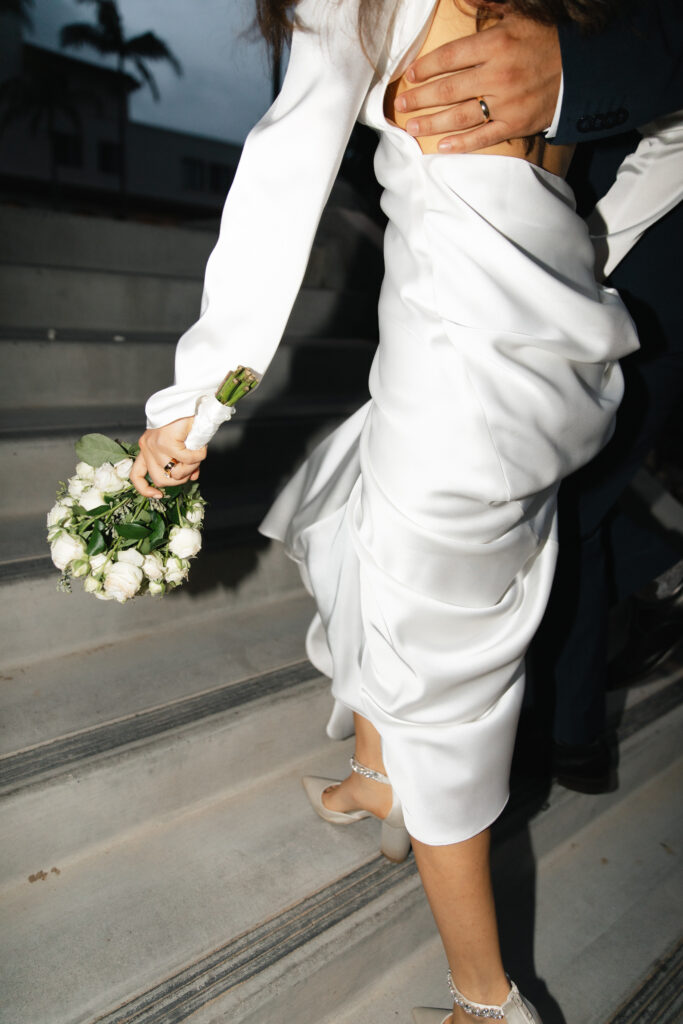 Joyful wedding day exit surrounded by family and friends.