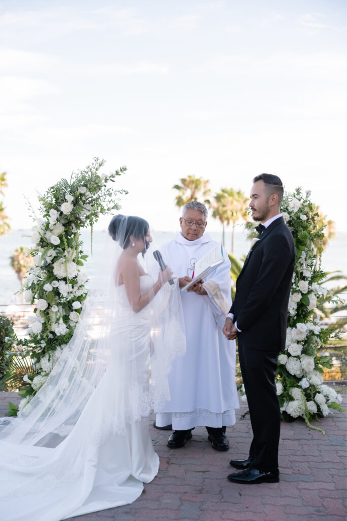 Bride and groom exchanging vows with ocean views.